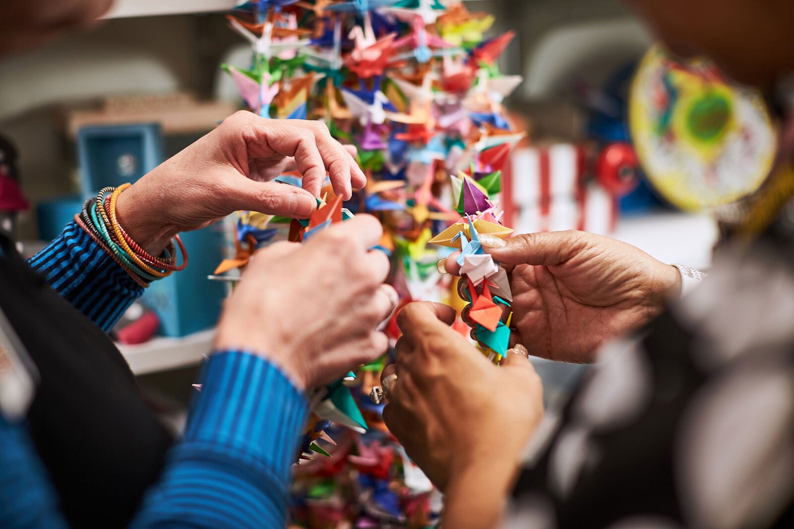 hands holding paper cranes