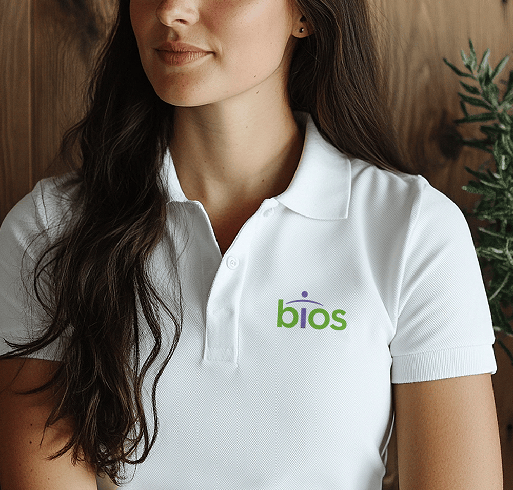 Female employee wearing white polo-style shirt featuring the Bios logo.